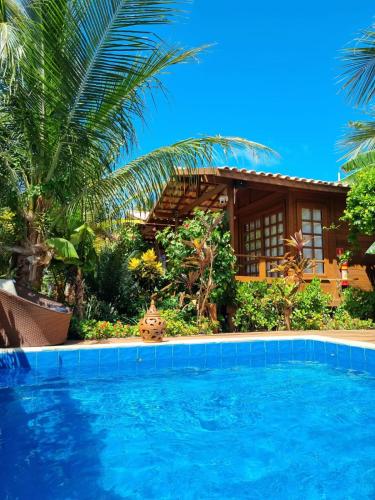 a resort with a swimming pool in front of a house at Pousada Villa del Lótus in Itarema