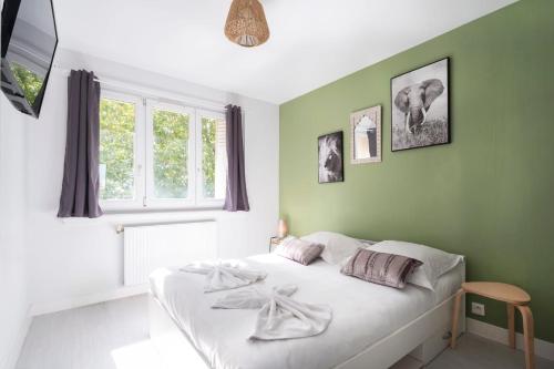 - un lit blanc dans une chambre aux murs verts dans l'établissement Le Grand Jau, à Metz