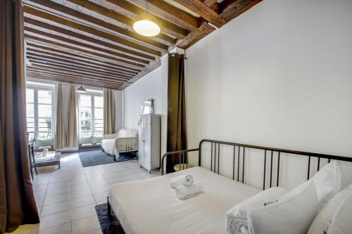 une chambre avec deux lits et un salon dans l'établissement Paris Marais Lombards, à Paris