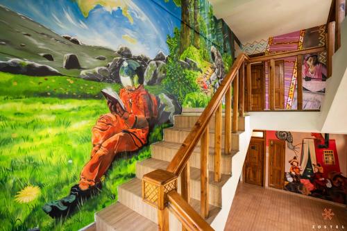 a mural on the wall of a house with stairs at Zostel Pulga in Pulga
