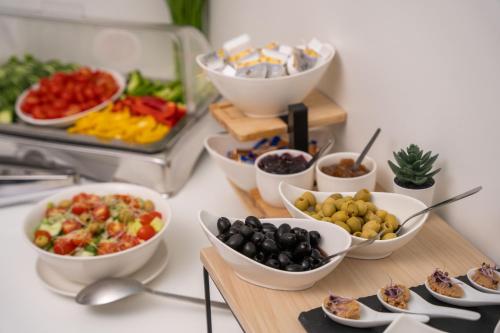 a table topped with bowls of different types of food at Escala Hotel & Suites in Budapest
