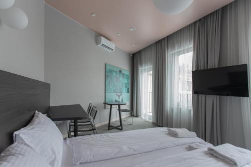 a bedroom with a bed and a desk and a television at Resume apartments in Kaunas