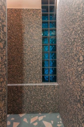 a bathroom with a shower with blue glass bottles at Resume apartments in Kaunas