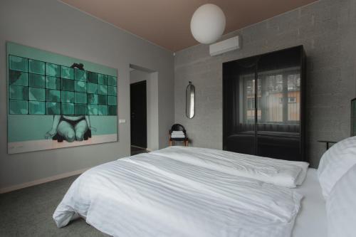 a bedroom with a white bed and a large window at Resume apartments in Kaunas