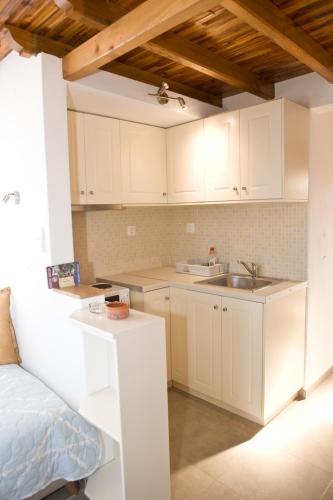 a kitchen with white cabinets and a sink at Panormos Maisonettes in Panormos Skopelos