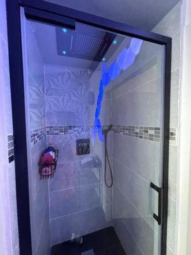 La salle de bains est pourvue d'une douche avec des lumières bleues. dans l'établissement Relaxation AquatiqueGarantie100%, à Saint-Estève