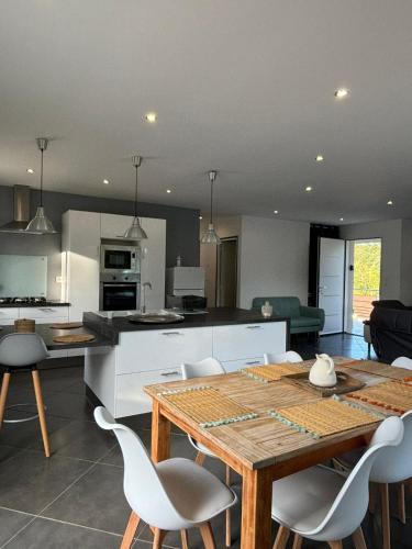 une cuisine et une salle à manger avec une table et des chaises en bois dans l'établissement La maison des Oliviers, 5min du ZooParc de Beauval, à Saint-Aignan