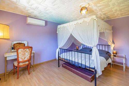 - une chambre avec un lit à baldaquin, un bureau et une chaise dans l'établissement Villa Sur la Colline by Villa Plus, à Les Adrets-de-l'Estérel