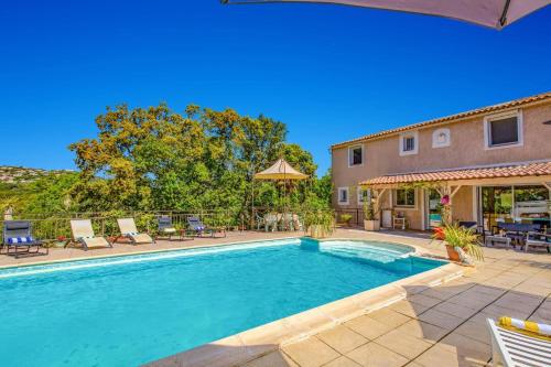 une piscine avec des chaises et une maison dans l'établissement Villa Sur la Colline by Villa Plus, à Les Adrets-de-l'Estérel