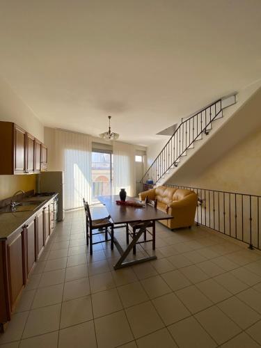 a kitchen and living room with a table and a couch at SteLuRe in Aradeo