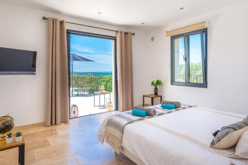 a bedroom with a large bed and a large window at Villa Mas des Lavandes by Villa Plus in Le Tignet