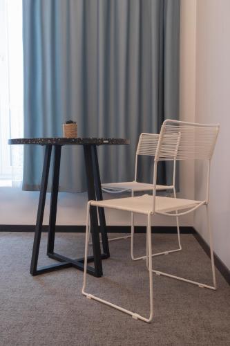 two chairs and a table and a table and chairs at Resume apartments in Kaunas
