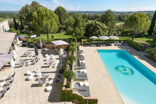 an overhead view of a pool with chairs and umbrellas at Hôtel Birdy by Happyculture in Aix-en-Provence
