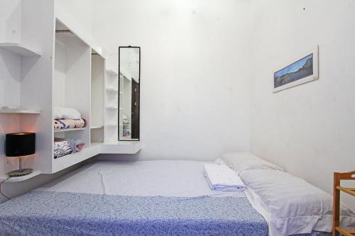 ein weißes Zimmer mit einem Bett und einem Spiegel in der Unterkunft Jmt star's inn in General Luna