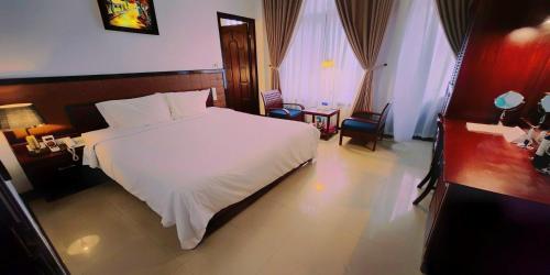 a bedroom with a large white bed in a room at Victory Hotel in Hue