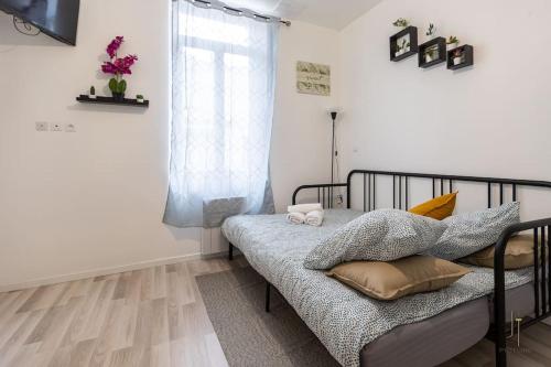 une chambre avec un lit avec des oreillers et une fenêtre dans l'établissement Super Studio Bien équipé, à Saint-Quentin