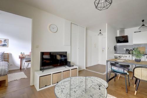 un salon avec une télévision et une salle à manger dans l'établissement Le Sahel ~ Parking ~ Patio, à Toulouse