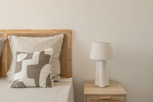 - un lit avec un oreiller et une lampe sur une table de nuit dans l'établissement OIQIA • Olympe, à Narbonne