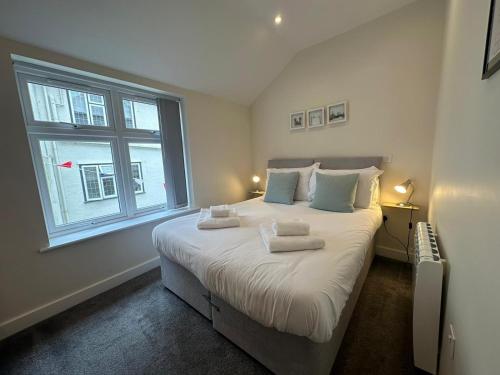 a bedroom with a large bed with towels on it at The Old Bakery in Fowey