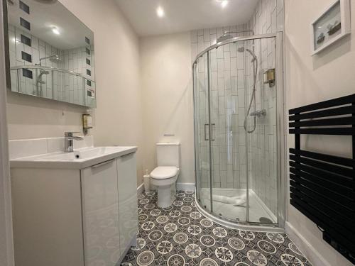 a bathroom with a shower and a sink and a toilet at The Old Bakery in Fowey