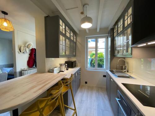 a kitchen with a wooden counter top and some windows at Jolie maison avec jardin a 100m de la plage in Étretat