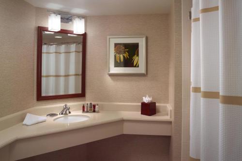 a bathroom with a sink and a mirror at Atlanta Marriott Alpharetta in Alpharetta