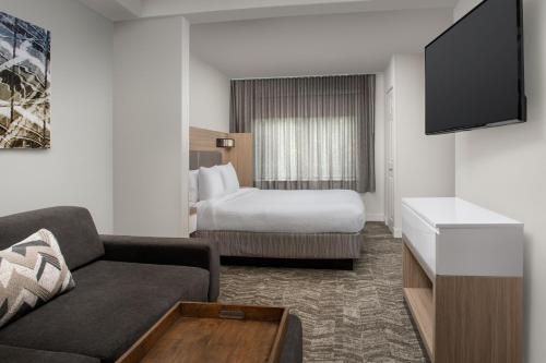 a hotel room with a couch and a bed at SpringHill Suites by Marriott Atlanta Buford/Mall of Georgia in Buford