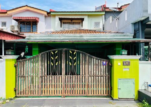 an entrance to a house with a wooden gate at Jizek Homestay Bajet in Rawang