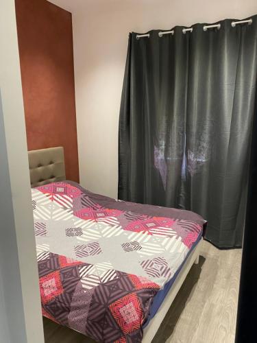 - une chambre avec un lit et un rideau noir dans l'établissement Type t3 Lancon de Provence, à Lançon-Provence