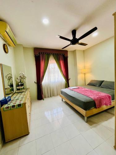 a bedroom with a bed and a ceiling fan at Jizek Homestay Bajet in Rawang