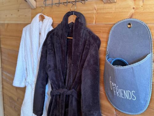a robe hanging on a wall next to a bag at Thethi Villas in Theth
