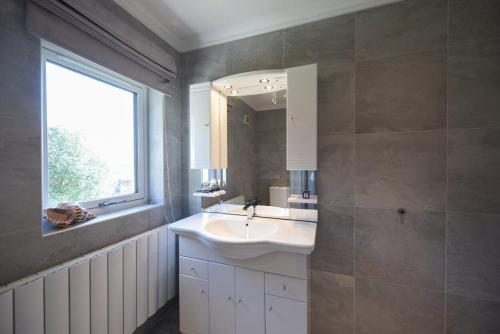 a bathroom with a sink and a window and a mirror at Braesyde in Kippford
