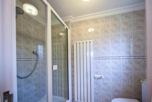 a bathroom with a shower with a glass door at Braesyde in Kippford