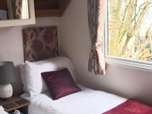 a bedroom with a bed with a window and a pillow at Parkview, Port Haverigg in Haverigg