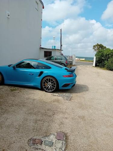 une voiture bleue garée devant un bâtiment dans l'établissement Appt T2 à 10 m de la plage, à Arcachon