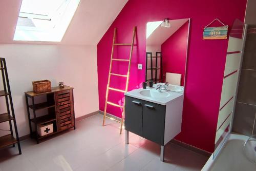 La salle de bains est pourvue d'un lavabo et d'un mur rose. dans l'établissement Chez Irène & Alan - Maison Pila, à La Fresnais