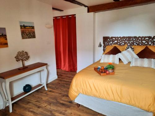 - une chambre avec un grand lit et un rideau rouge dans l'établissement La maison du tailleur de pierre, à Cordes-sur-Ciel