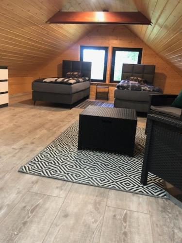 a living room with two beds and a rug at Mahoniowe Zacisze in Strzeszów