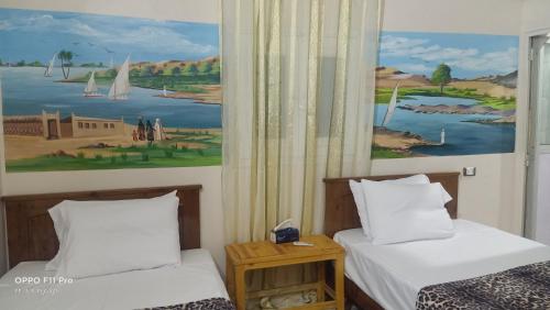 a room with two beds and a painting on the wall at Amon guest house in Abu Simbel