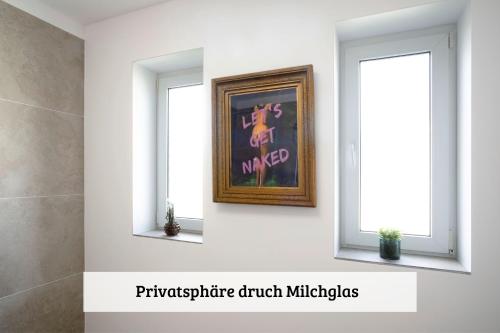 a painting in a room with two windows at LenHaus Sundern - Ferienhaus mit Kamin & Garten in Sundern