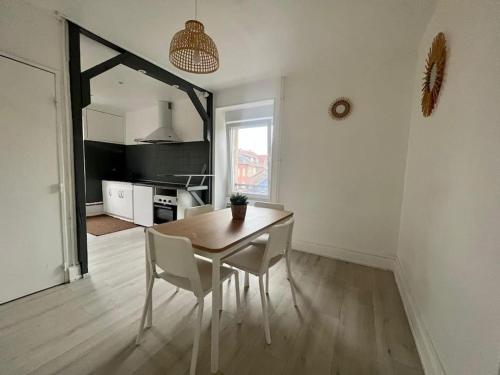 une cuisine et une salle à manger avec une table et des chaises dans l'établissement Le Guebwiller proche centre, à Belfort