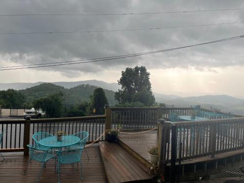 a wooden deck with a table and chairs on it at Skyline Village Inn in Spruce Pine