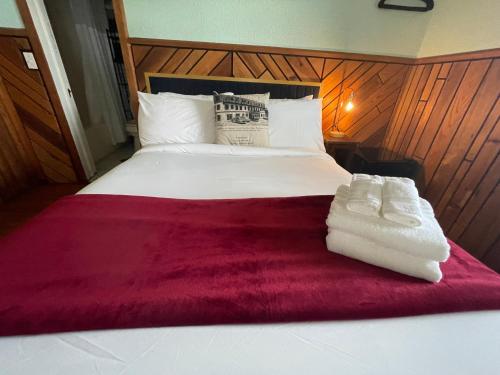 a bed with two white towels sitting on top of it at Skyline Village Inn in Spruce Pine