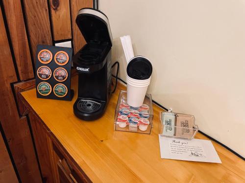 a counter with a coffee maker and cups on it at Skyline Village Inn in Spruce Pine