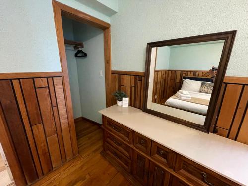 a dressing room with a mirror and a bed at Skyline Village Inn in Spruce Pine