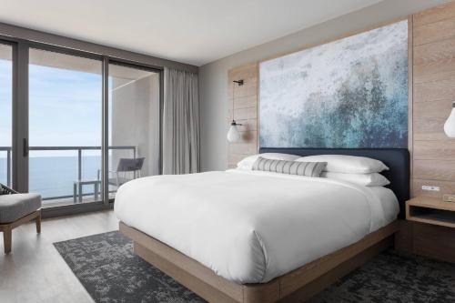 a bedroom with a large bed and a large window at Marriott Virginia Beach Oceanfront Resort in Virginia Beach