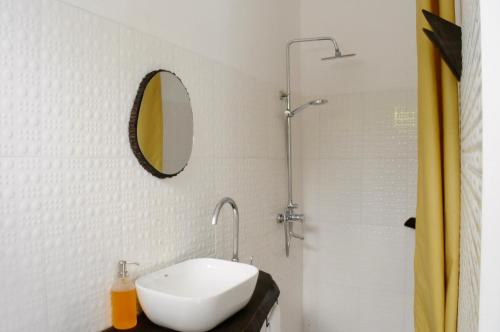 a white bathroom with a sink and a shower at OYA Guest House in Usa River