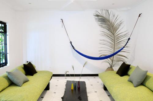 a living room with two couches and a plant at OYA Guest House in Usa River