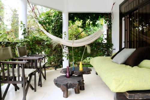 a living room with a couch and a hammock at OYA Guest House in Usa River