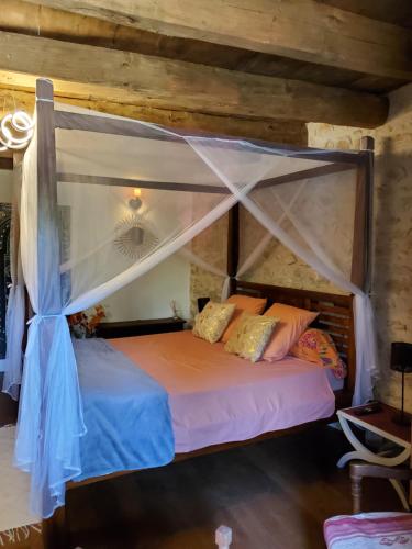 a bedroom with a bed with a canopy at chez Karine in Ceyzérieu
